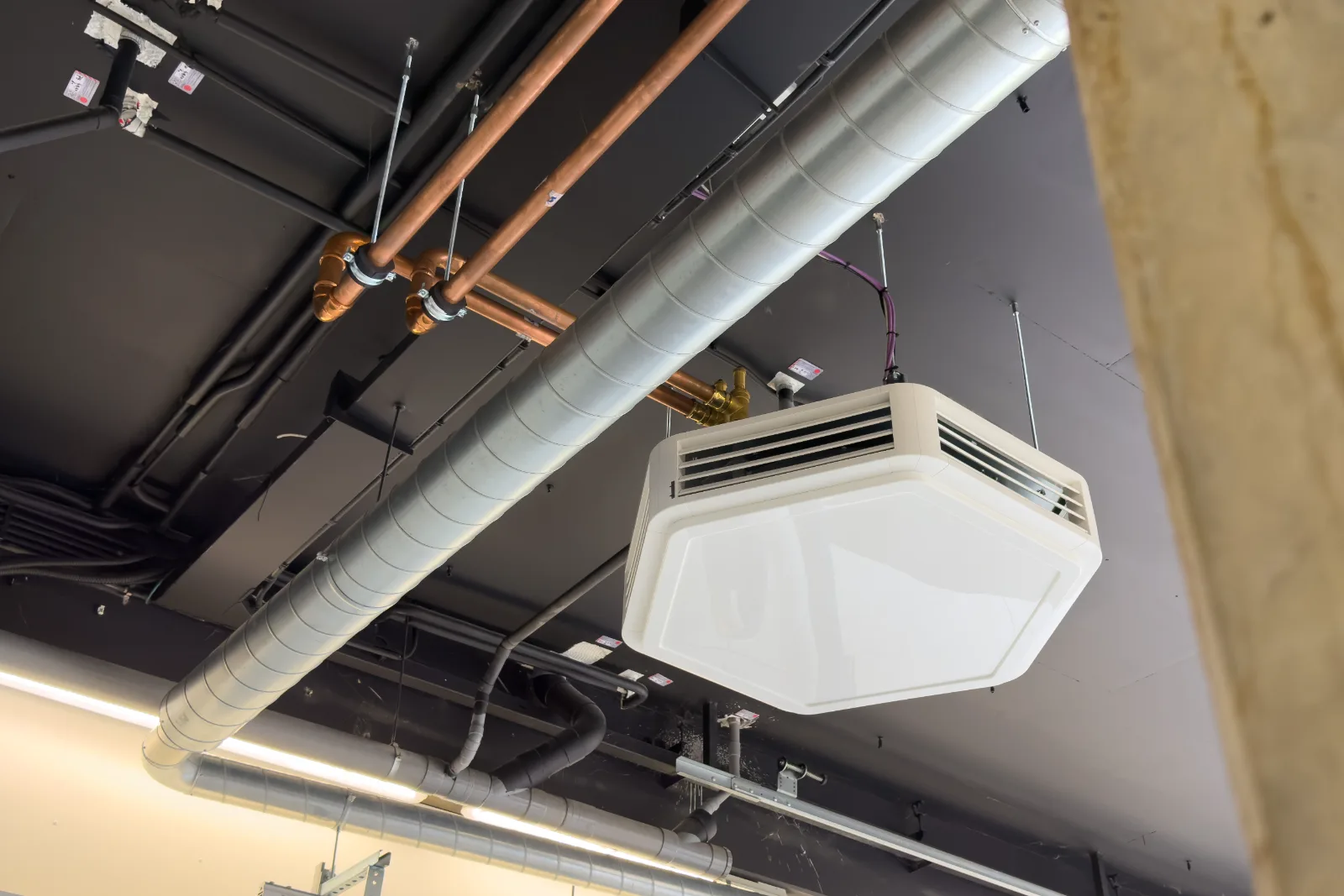 Klimaatunit en strak weggewerkt koper- en kanaalwerk in het plafond van de werkruimte.